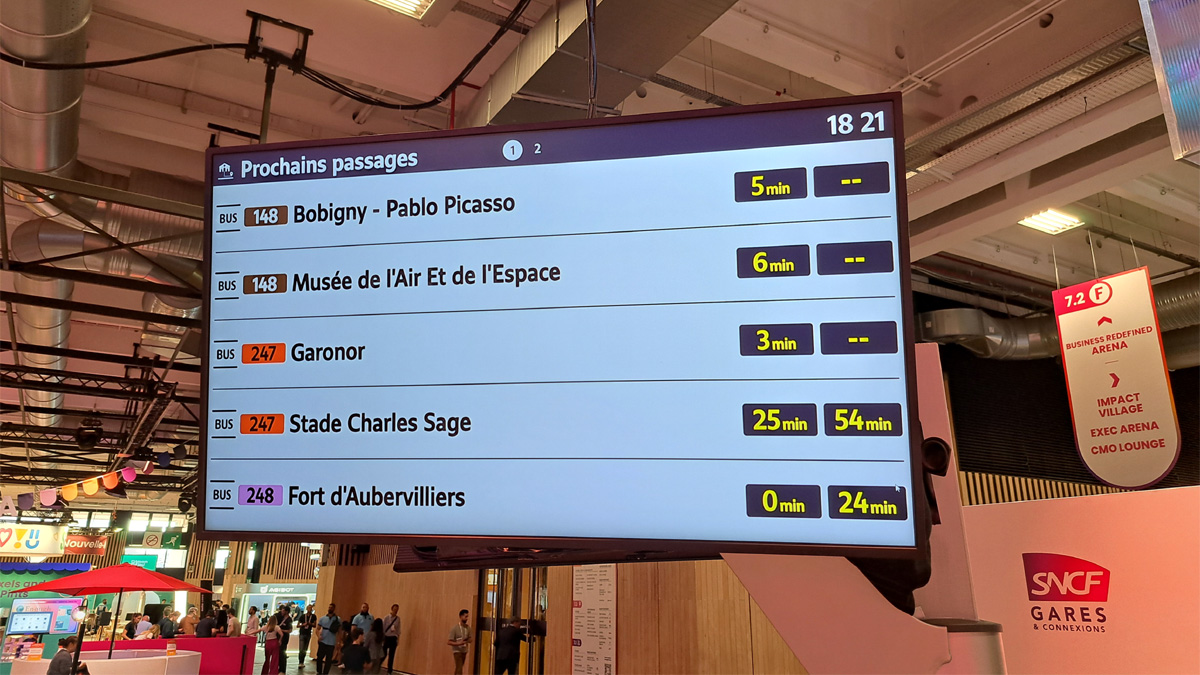 Démonstration d'un écran affichant les prochains départs des bus sur le stand SNCF à VivaTech